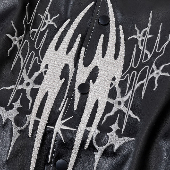 Close-up of the bomber jacket chest showing textured white tribal embroidery and black snap buttons