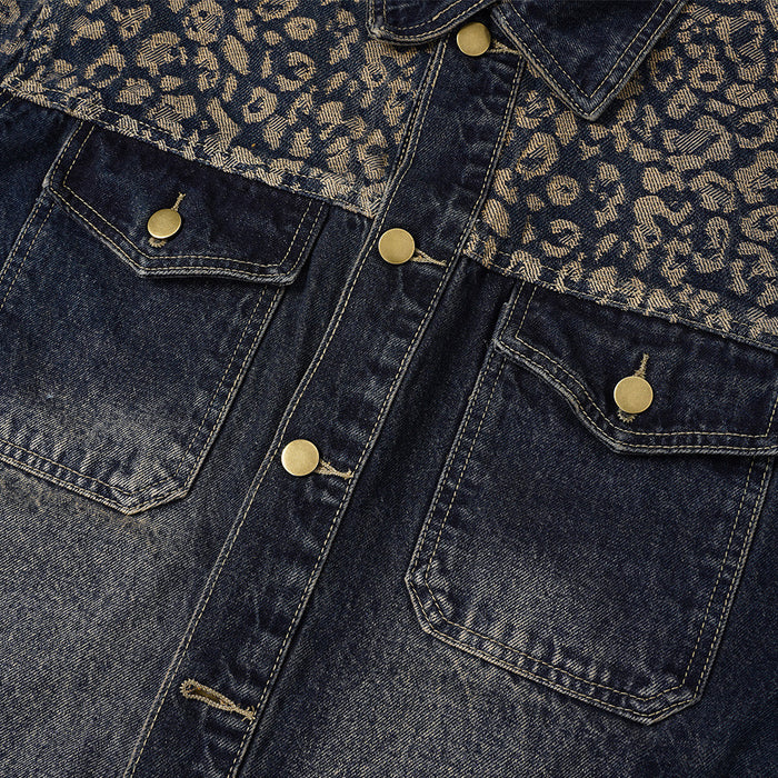 Close-up of the jacket front showing dark denim chest panels, pointed pocket flaps, stitching, and brass buttons