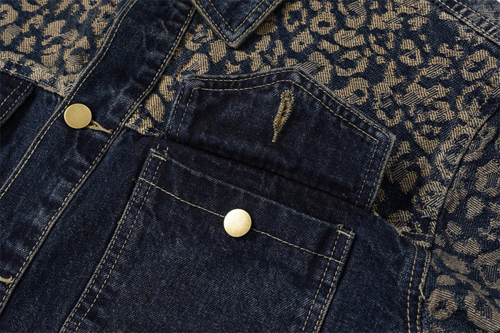Detailed view of a dark denim chest pocket with brass snap button against the leopard jacquard upper panel