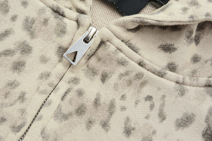Close-up of the hoodie front zipper with a silver pull and beige leopard-print fabric
