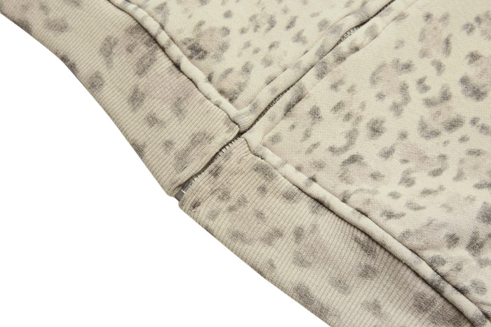 Close-up of a stitched seam and ribbed edge on the beige leopard-print hoodie