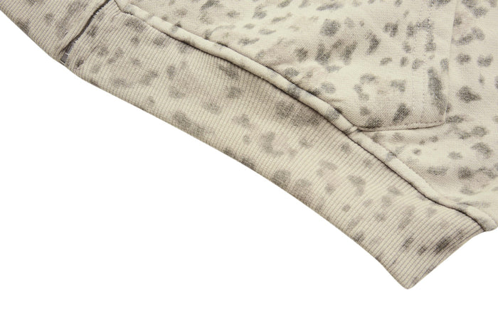 Close-up of the ribbed bottom hem on the beige leopard-print zip-up hoodie
