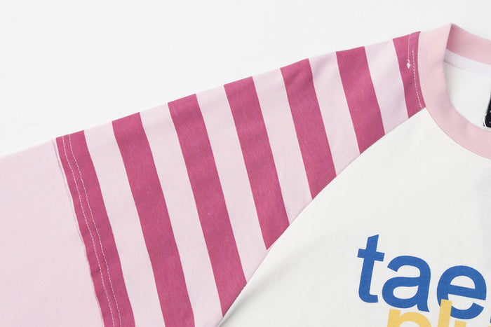 Close-up of the pink and white striped raglan shoulder beside the white shirt front
