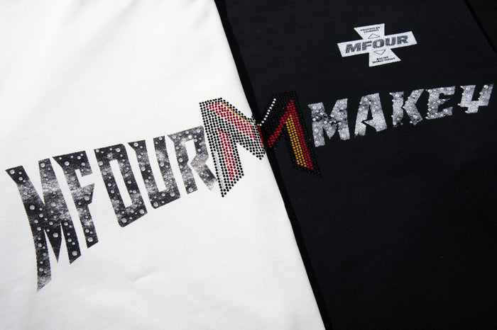 Close-up of distressed MFOUR MAKEY graphic spanning white and black shirt panels