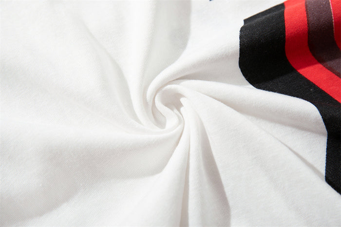 Close-up of the white jersey tee fabric gathered beside a visible black-red wavy stripe panel