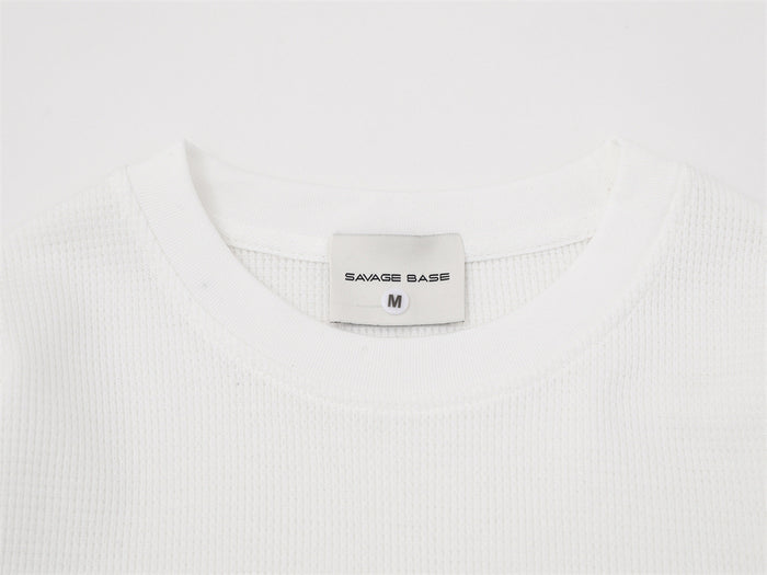 Close-up of the white crew neck collar with a Savage Base label marked size M