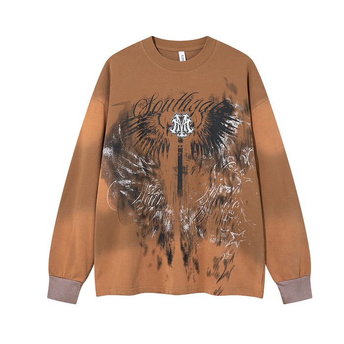 Front view of the tan oversized long sleeve shirt with a large black and white winged graphic and script print