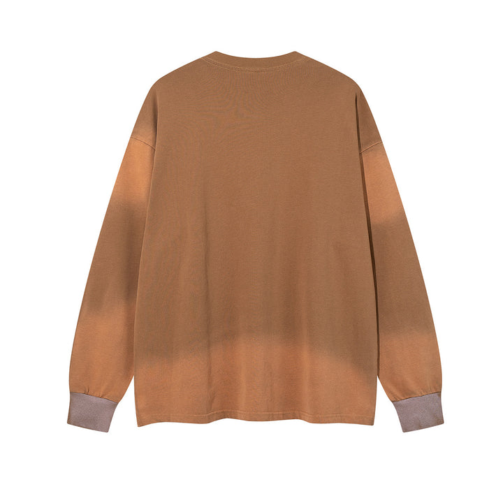 Back view of the tan oversized long sleeve shirt with subtle acid-wash shading and ribbed cuffs