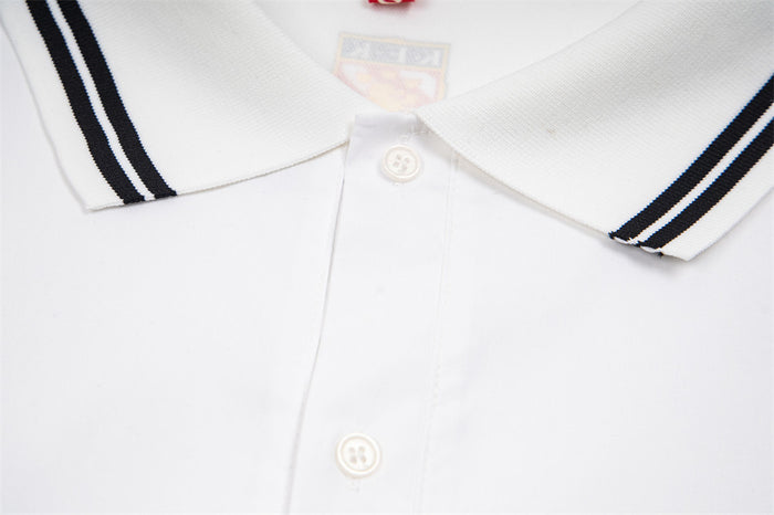 White polo shirt placket close-up showing two white buttons and black-striped collar edges