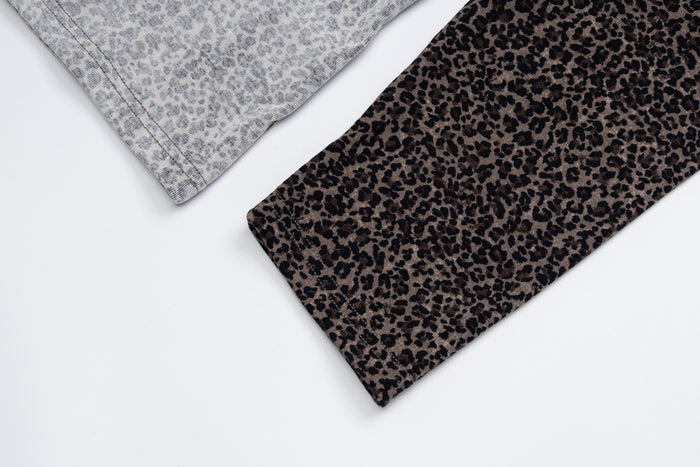 Close-up of the leopard-print sleeve edge beside the gray patterned shirt fabric and finished seam