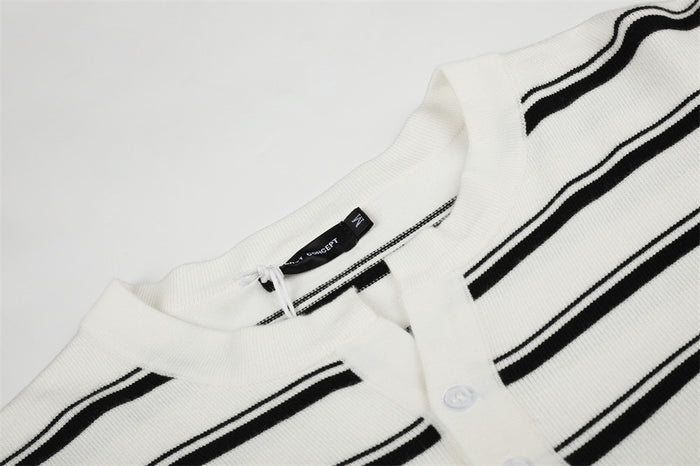 Close-up of a white striped knit sweater collar and henley placket with black stripe detailing