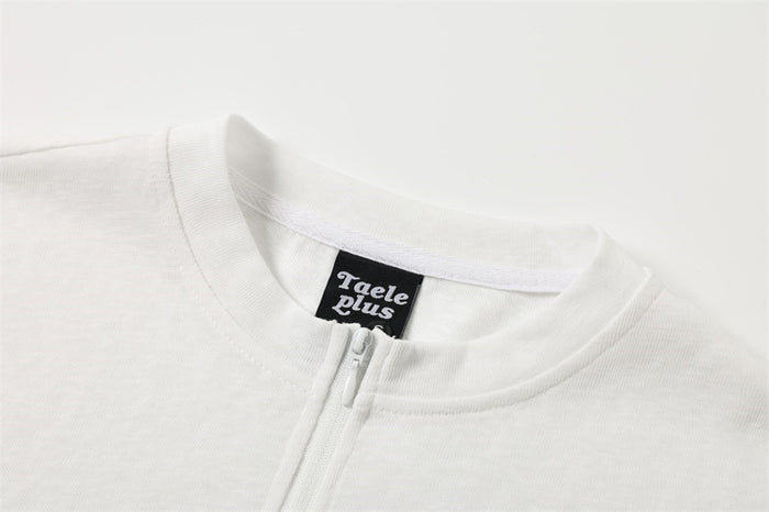 Close-up of the white shirt's ribbed round collar, front zipper, and sewn neck label