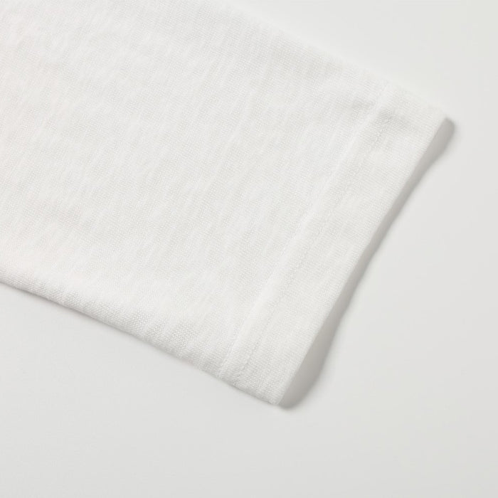 Close-up of the white shirt sleeve cuff showing the smooth knitted fabric and finished edge