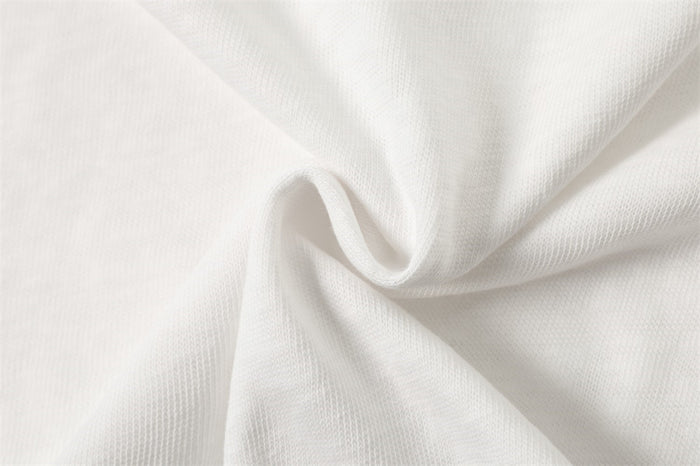 White shirt fabric gathered into folds, highlighting its fine textured weave and flexible drape