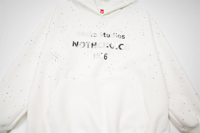 Close-up of the white hoodie front showing rhinestone splatter, reflective chest lettering, and kangaroo pocket