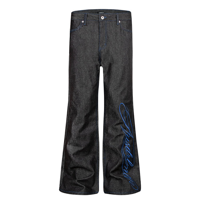 Front view of black bootcut jeans with blue script embroidery on the right leg