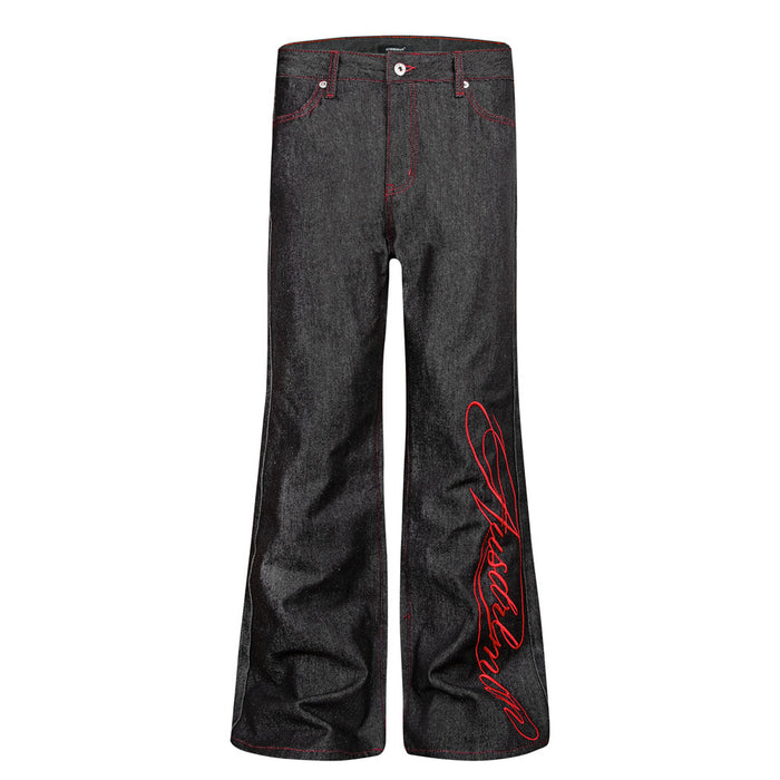 Front view of black bootcut jeans with red script embroidery on the right leg