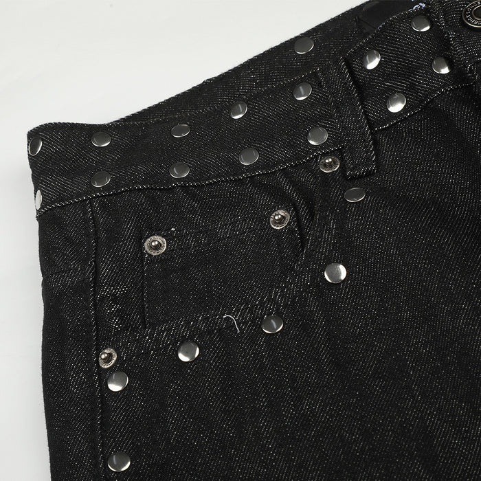 Close-up of a front pocket and waistband on black jeans with rows of silver studs