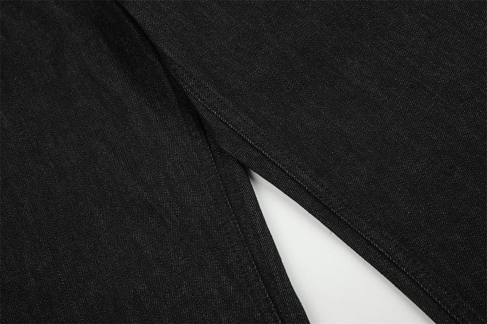 Close-up of black denim fabric and the inner leg seam of the bootcut jeans