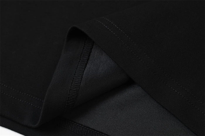 Close-up of black shirt fabric showing fine woven texture and folded seam detail