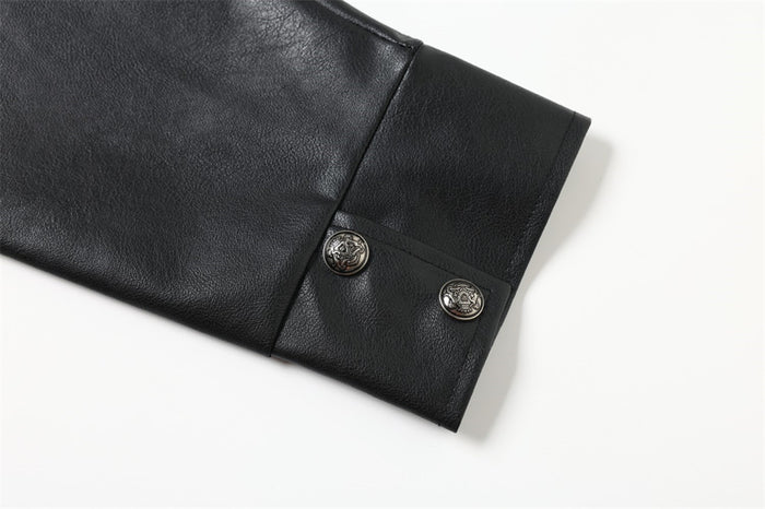 Close-up of black leather-look sleeve cuff with stitched panel and two decorative metal snap buttons