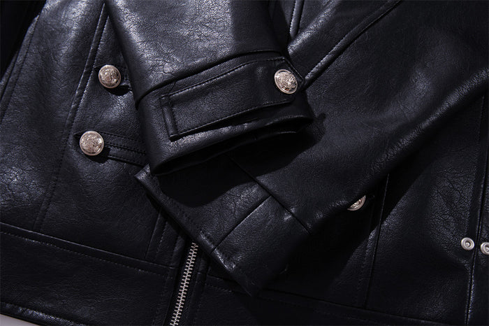 Close-up of the jacket sleeve cuff with a silver button over the black PU leather front