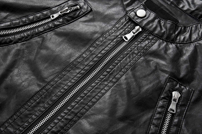 Close-up of black jacket front showing the central zipper, diagonal zippered pockets, and stitched panels