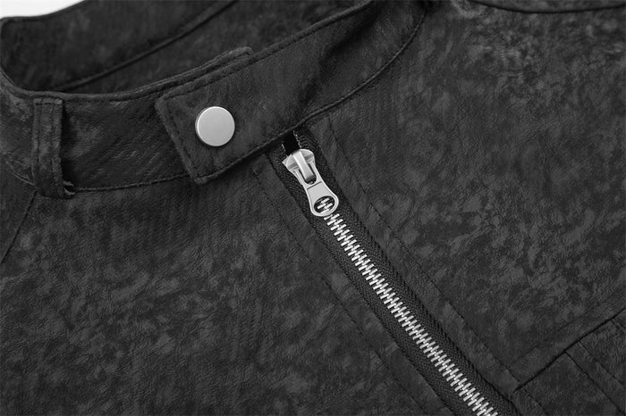Close-up of the textured black jacket front showing a snap collar tab and silver-toothed zipper