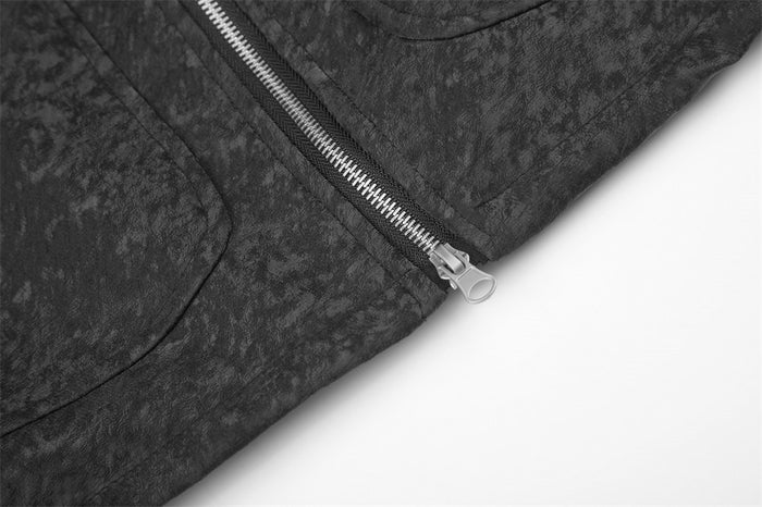 Close-up of the black jacket's lower front zipper and textured panel stitching