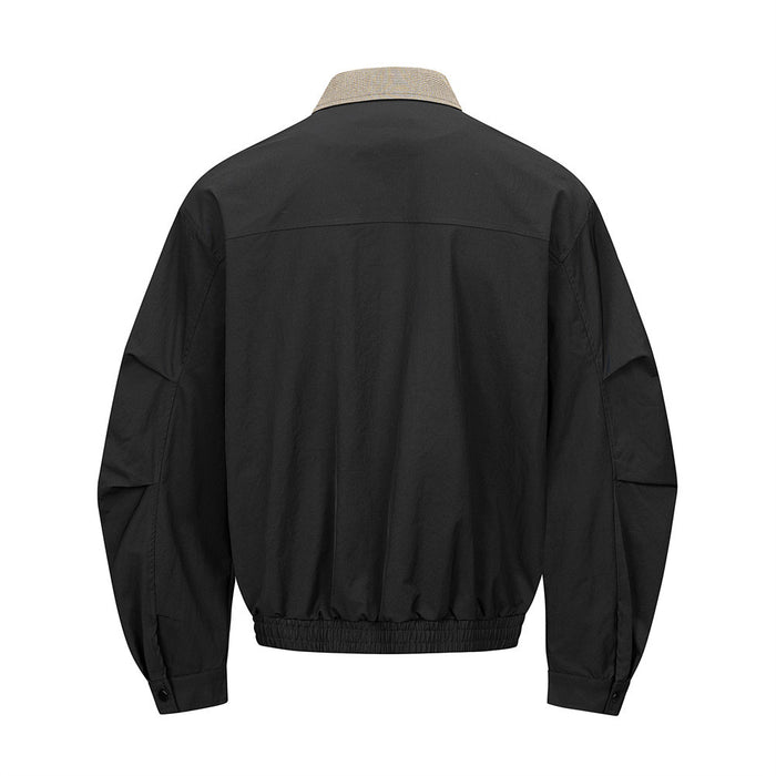 Black bomber jacket shown from the back with a brown houndstooth collar and elasticated hem