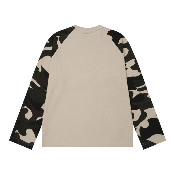 Back view of a beige raglan shirt with contrasting black, beige, and olive camouflage sleeves