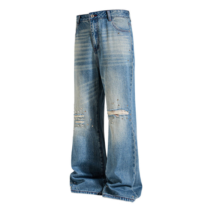 Angled front view of washed blue flare-leg jeans showing wide hems, distressed knees, and stud details