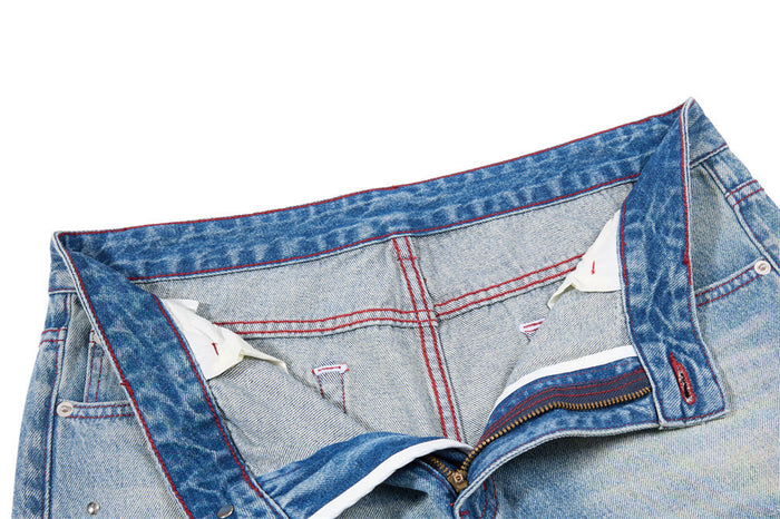 Open waistband and zipper fly showing the light denim interior and red-stitched construction