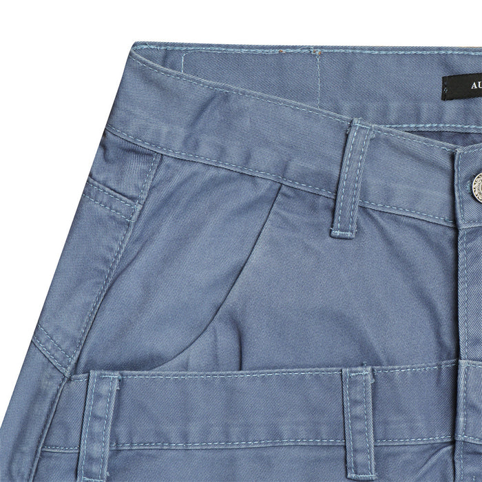 Close-up of a blue pants front pocket with belt loop, double waistband, stitching, and utility pocket detail