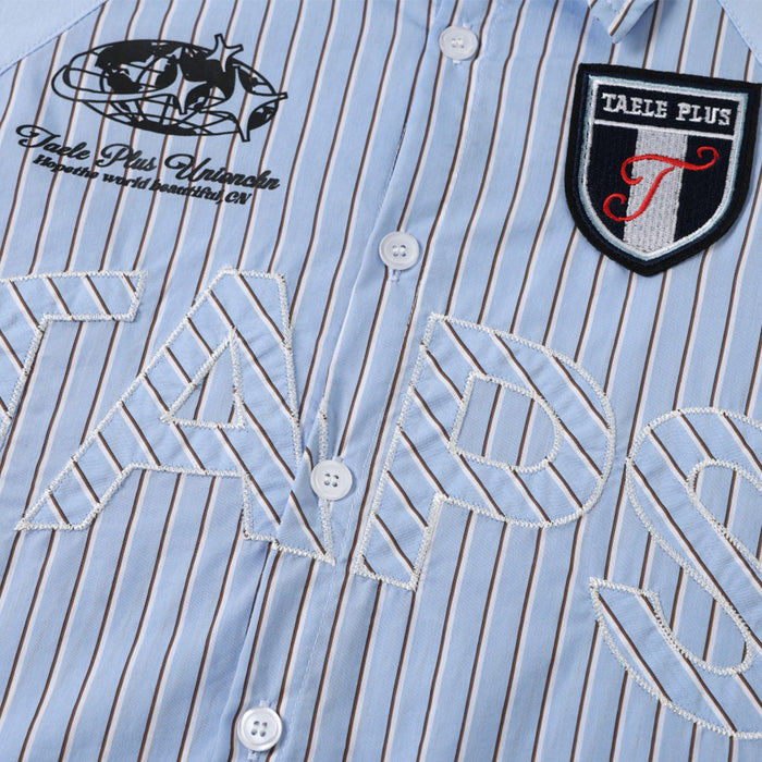 Close-up of striped shirt front showing white buttons, embroidered lettering, and shield-shaped chest patches