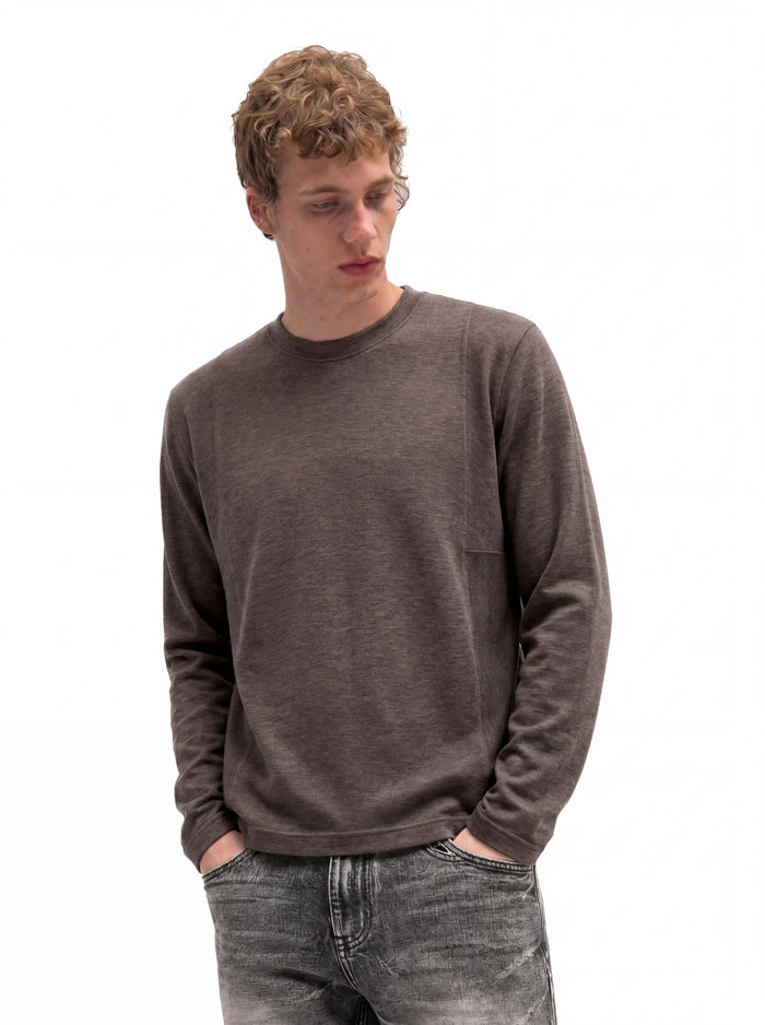 Man wearing a brown relaxed-fit long-sleeve crew neck shirt with both hands in his pockets