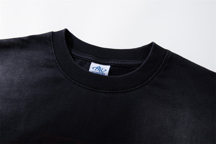 Close-up of the black shirt's ribbed crew neck, shoulder seam and sewn-in clothing label