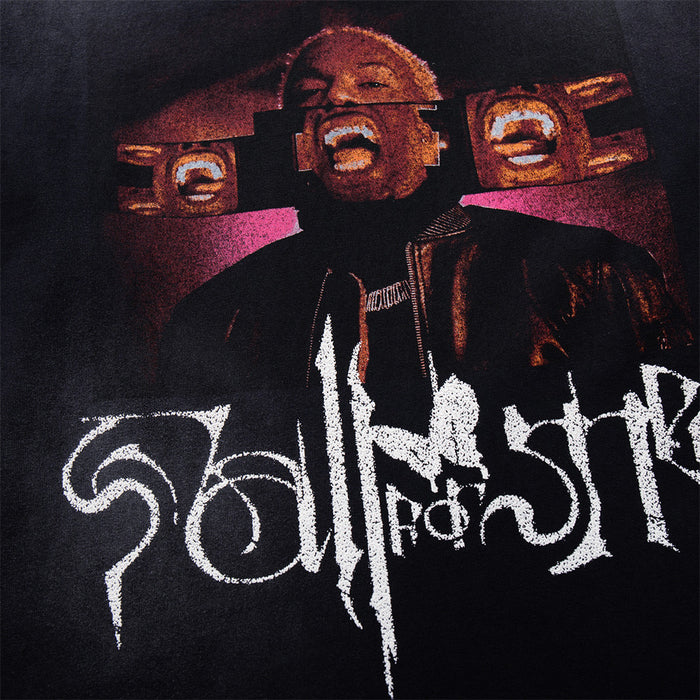 Close-up of the black shirt graphic featuring a portrait in red and orange tones above large white stylized lettering