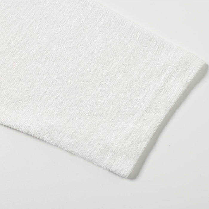 Close-up of the white shirt's finished edge with a subtly textured knit surface