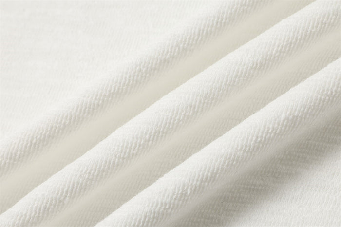 Close-up of white textured shirt fabric arranged in soft diagonal folds