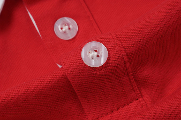 Close-up of two translucent buttons on the red rugby polo shirt's stitched front placket