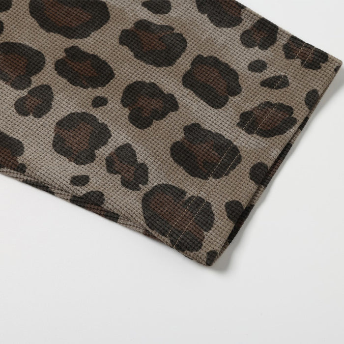 Close-up of the shirt sleeve showing brown and black leopard print on textured waffle fabric