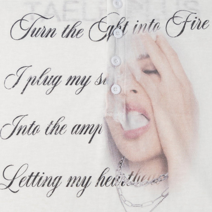 Detailed view of the white shirt graphic with black script lettering and a face touching its forehead