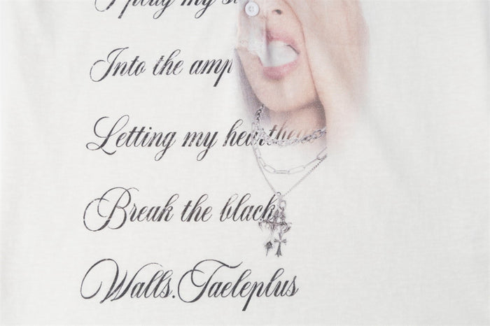 Lower graphic detail showing black cursive text, a necklace, and the bottom portion of the printed face
