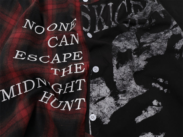 Close-up of the shirt front showing white text, distressed skull artwork, plaid panel, and white buttons