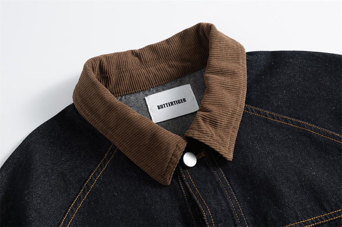 Close-up of the jacket's ribbed brown corduroy collar, top snap, and dark denim seams