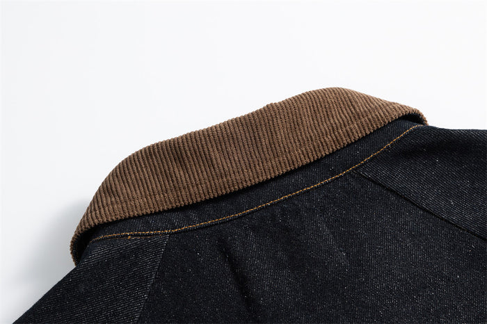 Close-up of the brown corduroy collar resting over the jacket's dark denim back seam