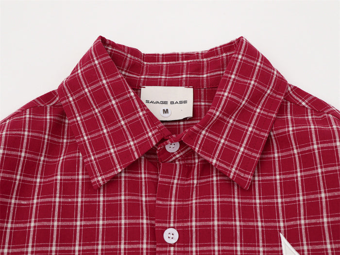 Close-up of the red plaid shirt collar, white buttons, and sewn neck label