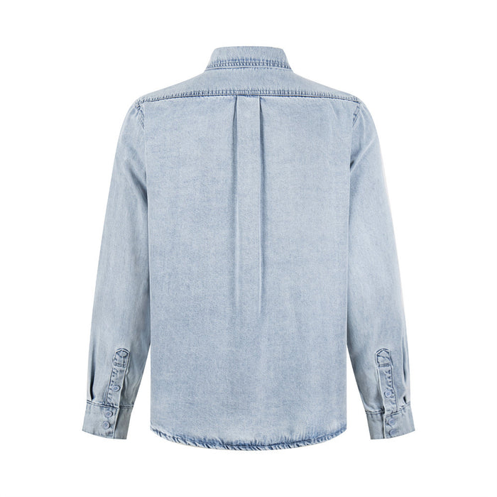 Light wash denim shirt back showing the yoke seam, center pleat, long sleeves, and buttoned cuffs