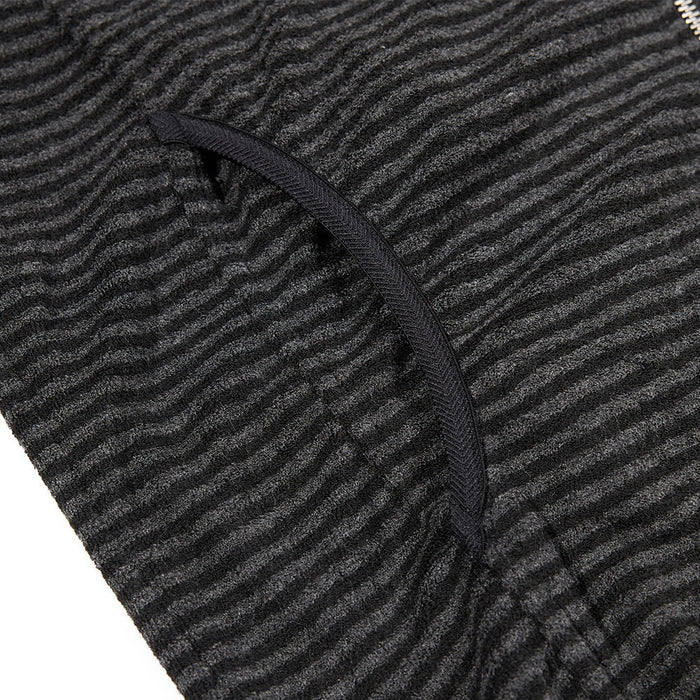 Close-up of a curved welt pocket opening on the black and gray striped jacket